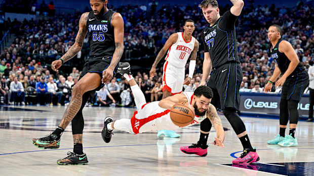Rockets guard Fred VanVleet is tripped up in front of Dallas Mavericks forward Derrick Jones Jr. and guard Luka Doncic